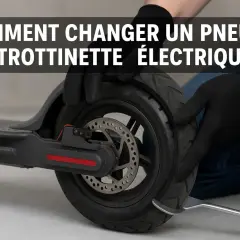Maintenant, démonte le pneu de ta trottinette électrique. Des mains gantées utilisent un levier pour retirer le pneu usé.