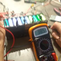 Diagnostic d'un **problème batterie** sur une **draisienne Moovway**. Un multimètre affiche 38.5V, mesurant la tension d'un pack d'accus.
