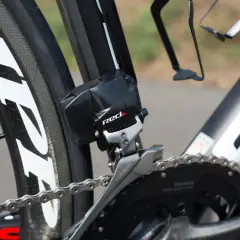 Dérailleur avant SRAM RED, essentiel pour le réglage plateau vélo. La chaîne argentée est visible sur le pédalier noir.