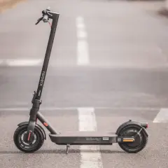 Trottinette électrique Xiaomi Pro 4, noire, sur une route avec marquage blanc.