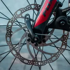 Gros plan sur le frein hydraulique VTT mou, avec son disque perforé et son étrier Tektro. Le levier de blocage rapide est visible.