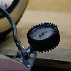Manomètre mesurant la pression pneu vélo électrique Nakamura. Le pneu est visible, ainsi que le tuyau de la pompe.