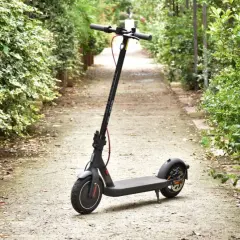 Trottinette électrique Xiaomi Mi 4 garée sur un chemin bordé de verdure.