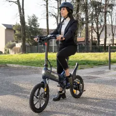 Femme en costume sur une trottinette Urban Glide, vérifiant la pression pneu trottinette urban glide pour une balade urbaine parfaite.
