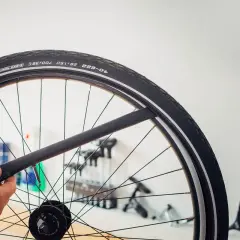 Main d'un cycliste tenant une chambre à air de vélo, prête à être installée. La durée de vie chambre à air vélo dépend de son entretien.