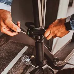 Un homme utilise une clé pour activer l'antivol de sa trottinette électrique, assurant ainsi sa sécurité.