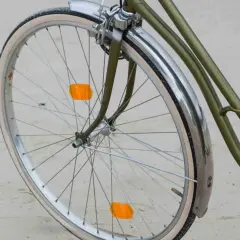 Roue de vélo verte avec garde-boue chromé et deux catadioptres orange pour la sécurité.