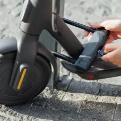 Maintenant, je sais comment cadenasser une trottinette. Des mains insèrent une clé dans un cadenas attaché au cadre de la trottinette.