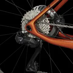 Détail du dérailleur et de la cassette d'un vélo électrique orange. Apprenez comment passer les vitesses sur un vélo électrique pour une conduite optimale.