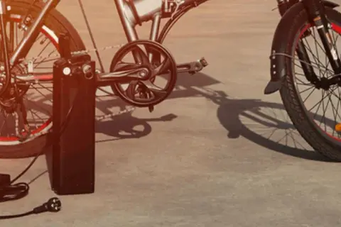 Vélo électrique Xiaomi en charge avec son chargeur.
