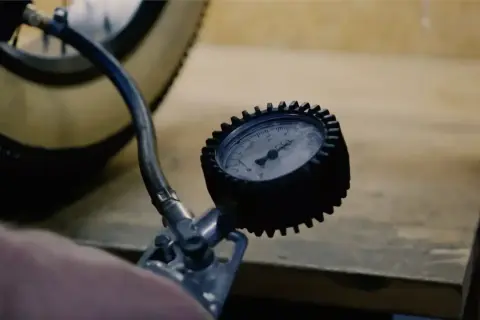 Manomètre mesurant la pression pneu vélo électrique Nakamura. Le pneu est visible, ainsi que le tuyau de la pompe.
