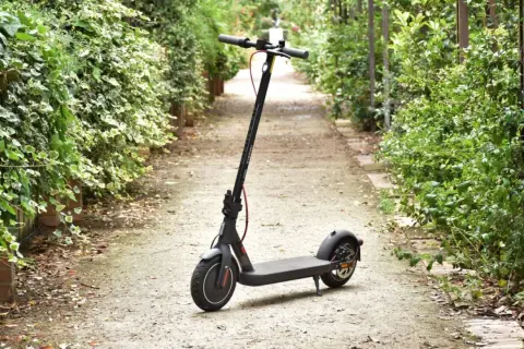 Trottinette électrique Xiaomi Mi 4 garée sur un chemin bordé de verdure.