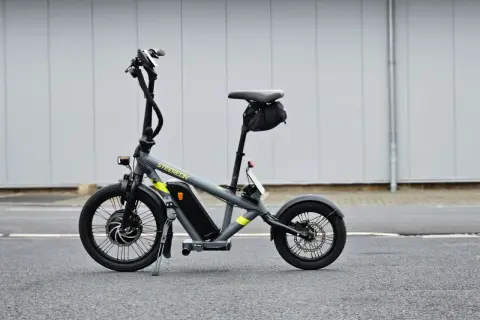 Draisienne électrique pliante grise, prête pour l'aventure urbaine.