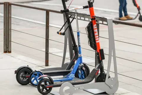 Trottinettes électriques garées, certaines avec un antivol. Une alarme trottinette électrique pourrait dissuader les voleurs.