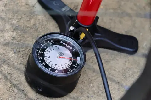 Manomètre de pompe VTT affichant la pression pneu tubeless. Le cadran indique environ 30 PSI.