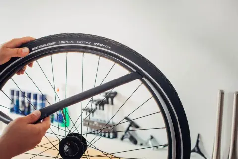 Main d'un cycliste tenant une chambre à air de vélo, prête à être installée. La durée de vie chambre à air vélo dépend de son entretien.