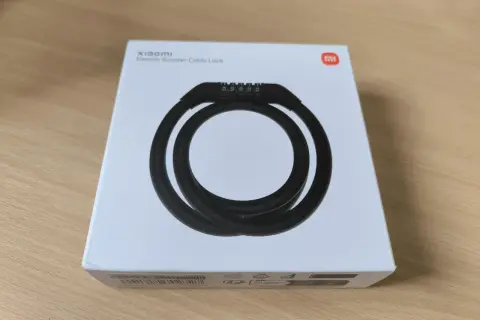 Boîte blanche avec un antivol Xiaomi pour trottinette électrique. Le câble noir est enroulé et un code à 5 chiffres est visible.