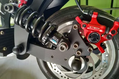 Amortisseur Speedway 5, système de freinage XTECH rouge et roue arrière d'un scooter électrique.
