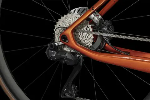 Détail du dérailleur et de la cassette d'un vélo électrique orange. Apprenez comment passer les vitesses sur un vélo électrique pour une conduite optimale.