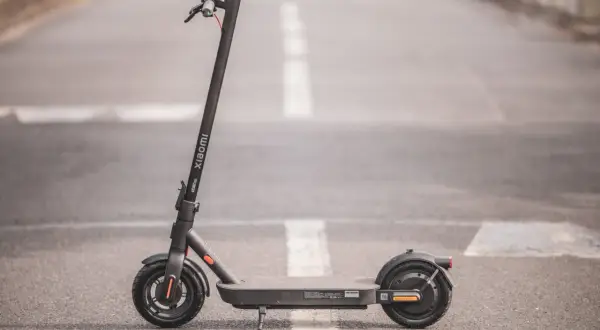 Trottinette électrique Xiaomi Pro 4, noire, sur une route avec marquage blanc.