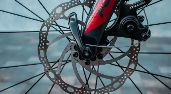 Gros plan sur le frein hydraulique VTT mou, avec son disque perforé et son étrier Tektro. Le levier de blocage rapide est visible.