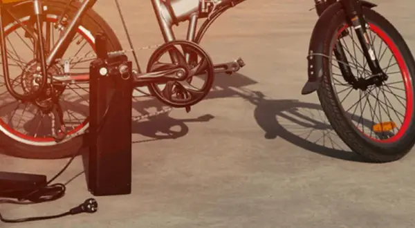 Vélo électrique Xiaomi en charge avec son chargeur.