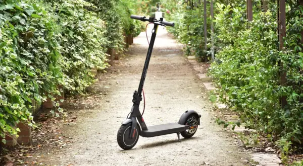 Trottinette électrique Xiaomi Mi 4 garée sur un chemin bordé de verdure.