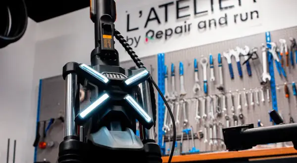 Le guidon d'une trottinette électrique avec ses feux lumineux, prêt pour une réparation à l'atelier.