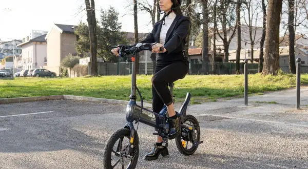 Femme en costume sur une trottinette Urban Glide, vérifiant la pression pneu trottinette urban glide pour une balade urbaine parfaite.