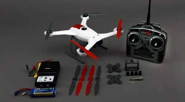 Ensemble de drone blanc et rouge, télécommande, chargeur, batterie et hélices. Le flyblade 350 dynamic débridage prêt à voler.