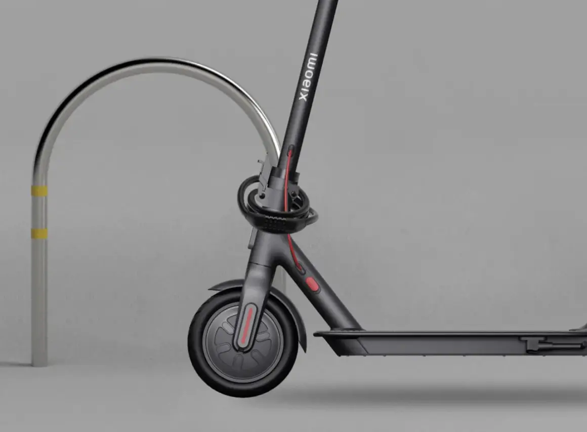Trottinette électrique Xiaomi sécurisée par un antivol intégré, attachée à un arceau métallique.
