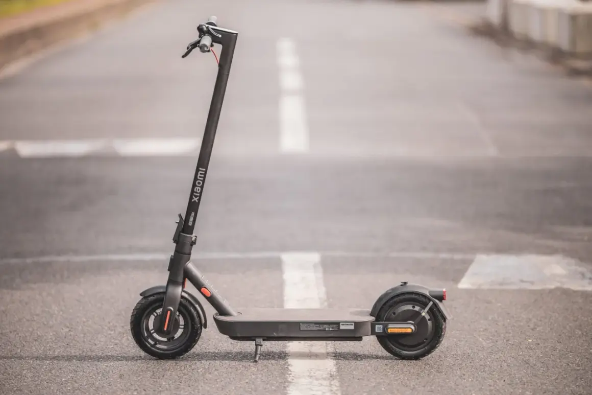 Trottinette électrique Xiaomi Pro 4, noire, sur une route avec marquage blanc.