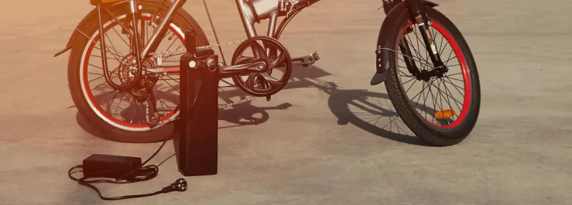 Vélo électrique Xiaomi en charge avec son chargeur.