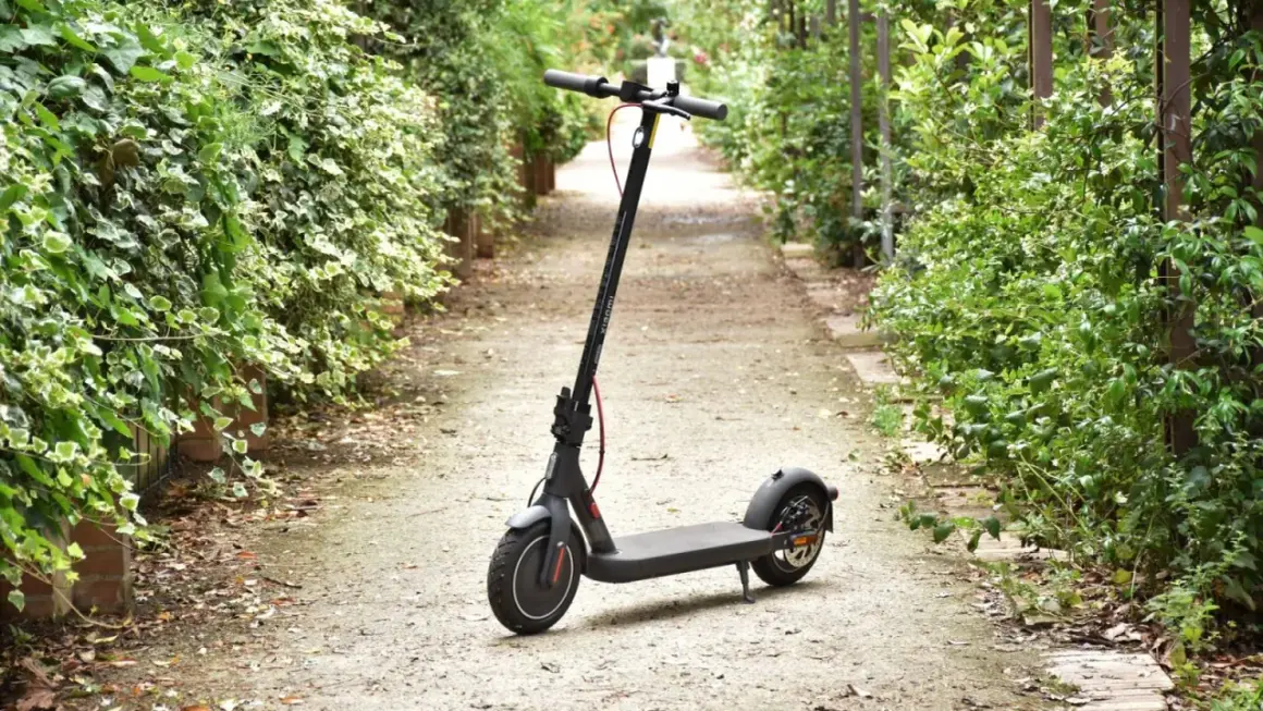 Trottinette électrique Xiaomi Mi 4 garée sur un chemin bordé de verdure.