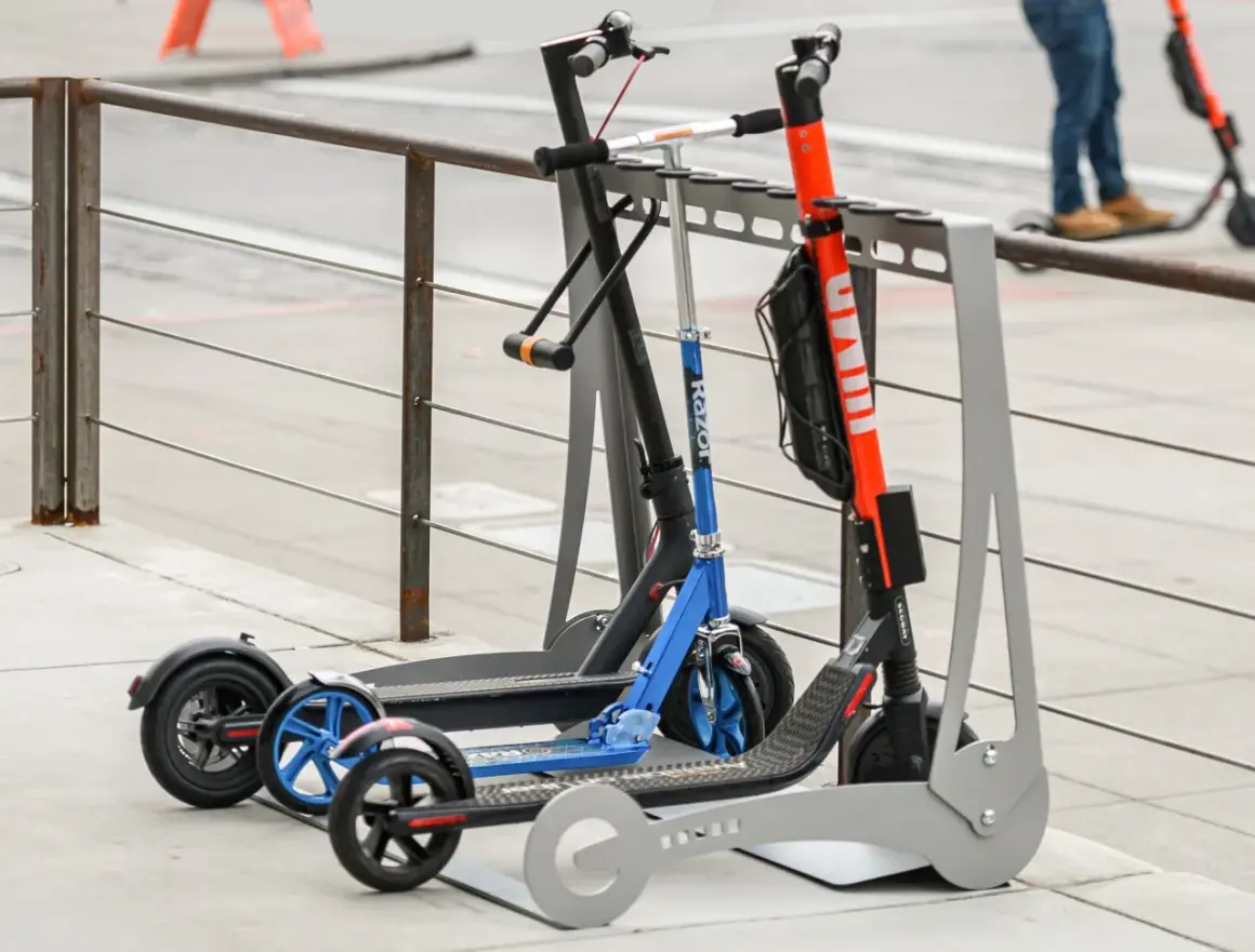 Trottinettes électriques garées, certaines avec un antivol. Une alarme trottinette électrique pourrait dissuader les voleurs.