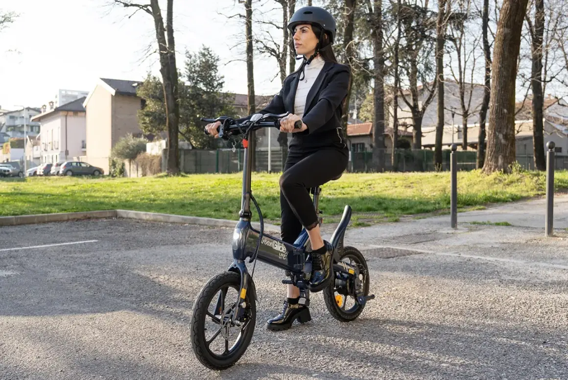 Femme en costume sur une trottinette Urban Glide, vérifiant la pression pneu trottinette urban glide pour une balade urbaine parfaite.