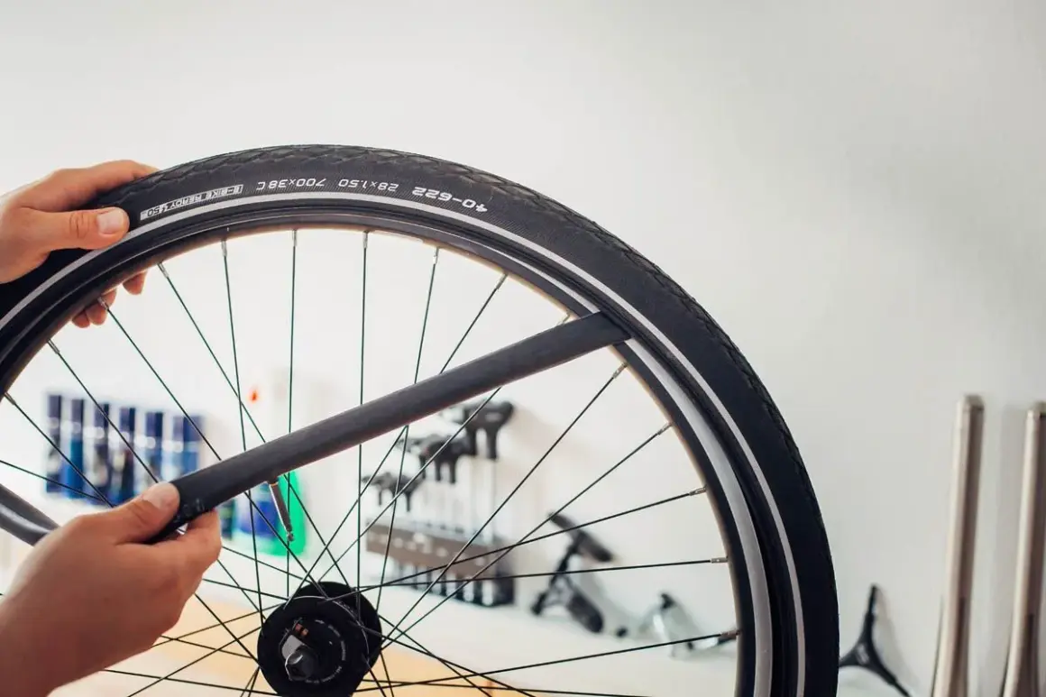 Main d'un cycliste tenant une chambre à air de vélo, prête à être installée. La durée de vie chambre à air vélo dépend de son entretien.