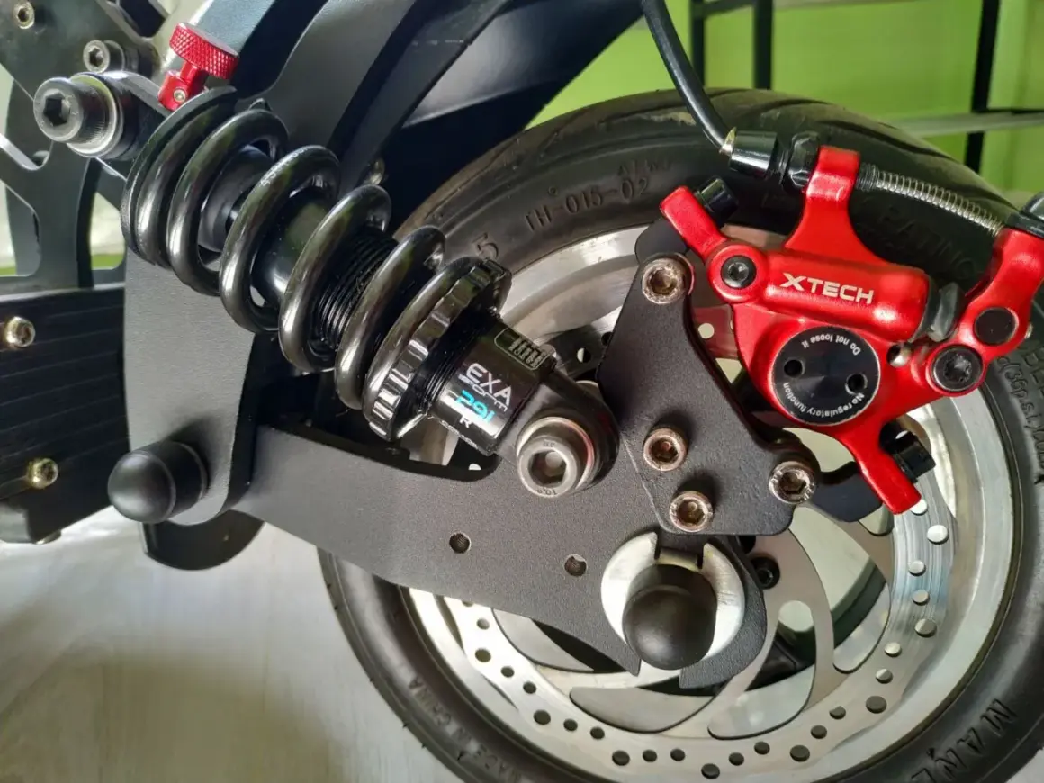 Amortisseur Speedway 5, système de freinage XTECH rouge et roue arrière d'un scooter électrique.