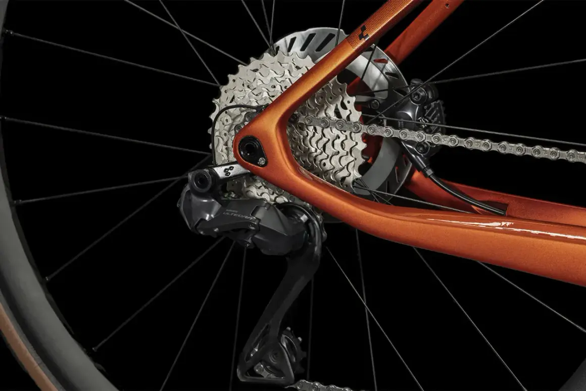 Détail du dérailleur et de la cassette d'un vélo électrique orange. Apprenez comment passer les vitesses sur un vélo électrique pour une conduite optimale.