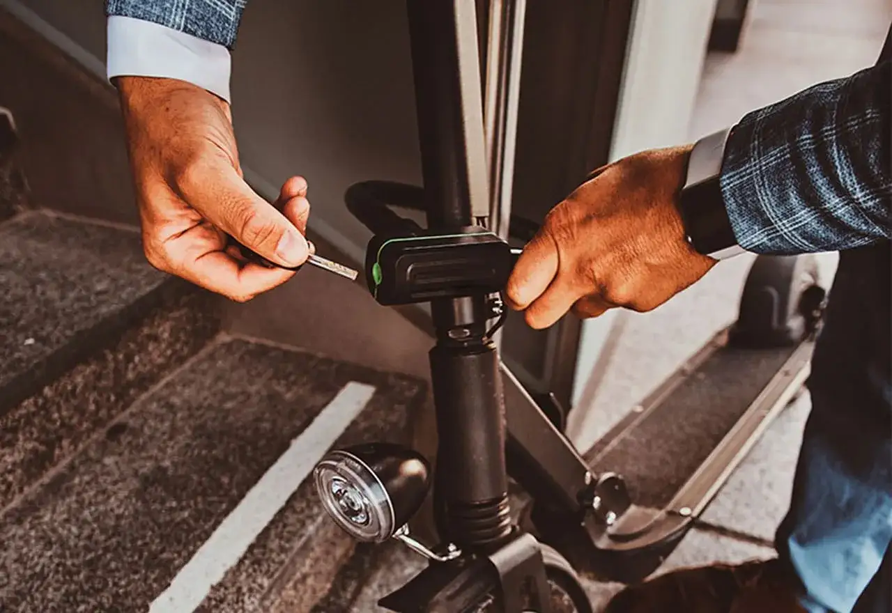 Un homme ins&egrave;re une cl&eacute; pour d&eacute;marrer son vol en trottinette &eacute;lectrique.