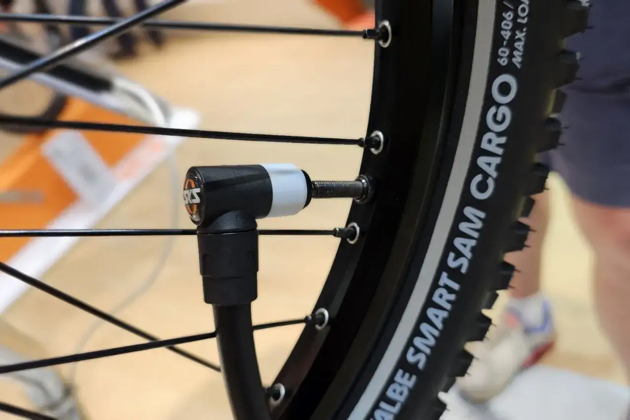 Adaptateur de pompe connecté à la valve d'un pneu de vélo électrique Nakamura. Vérification de la pression.