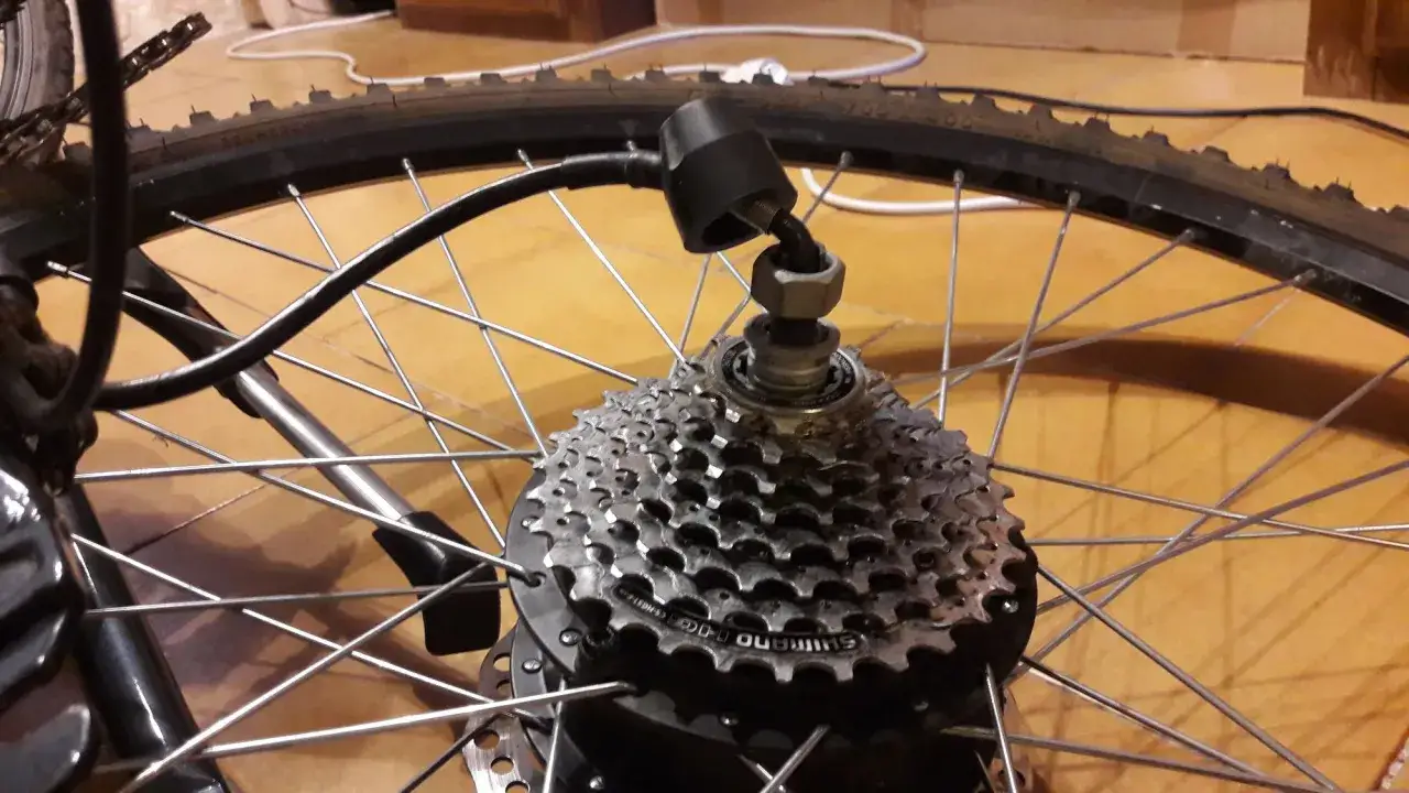 D&eacute;monter roue arri&egrave;re v&eacute;lo &eacute;lectrique : un capteur noir est fix&eacute; sur la cassette Shimano, pr&ecirc;t pour le d&eacute;montage.