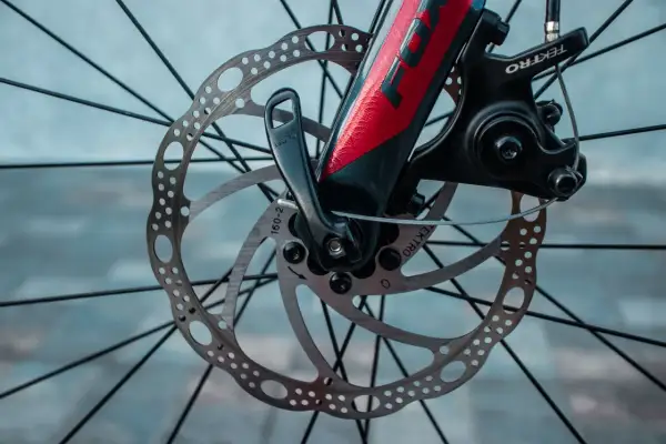 Gros plan sur le frein hydraulique VTT mou, avec son disque perforé et son étrier Tektro. Le levier de blocage rapide est visible.