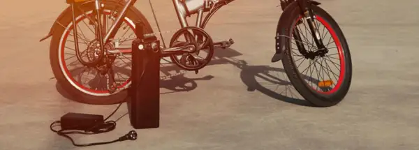 Vélo électrique Xiaomi en charge avec son chargeur.