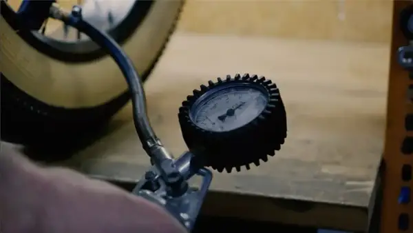Manomètre mesurant la pression pneu vélo électrique Nakamura. Le pneu est visible, ainsi que le tuyau de la pompe.