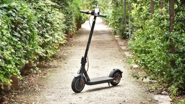 Trottinette électrique Xiaomi Mi 4 garée sur un chemin bordé de verdure.