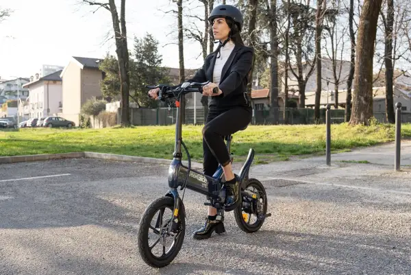 Femme en costume sur une trottinette Urban Glide, vérifiant la pression pneu trottinette urban glide pour une balade urbaine parfaite.