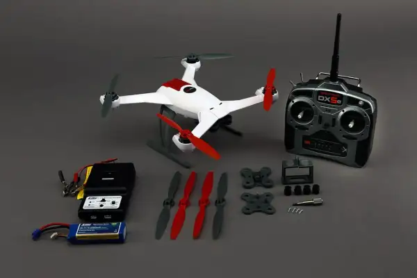 Ensemble de drone blanc et rouge, télécommande, chargeur, batterie et hélices. Le flyblade 350 dynamic débridage prêt à voler.